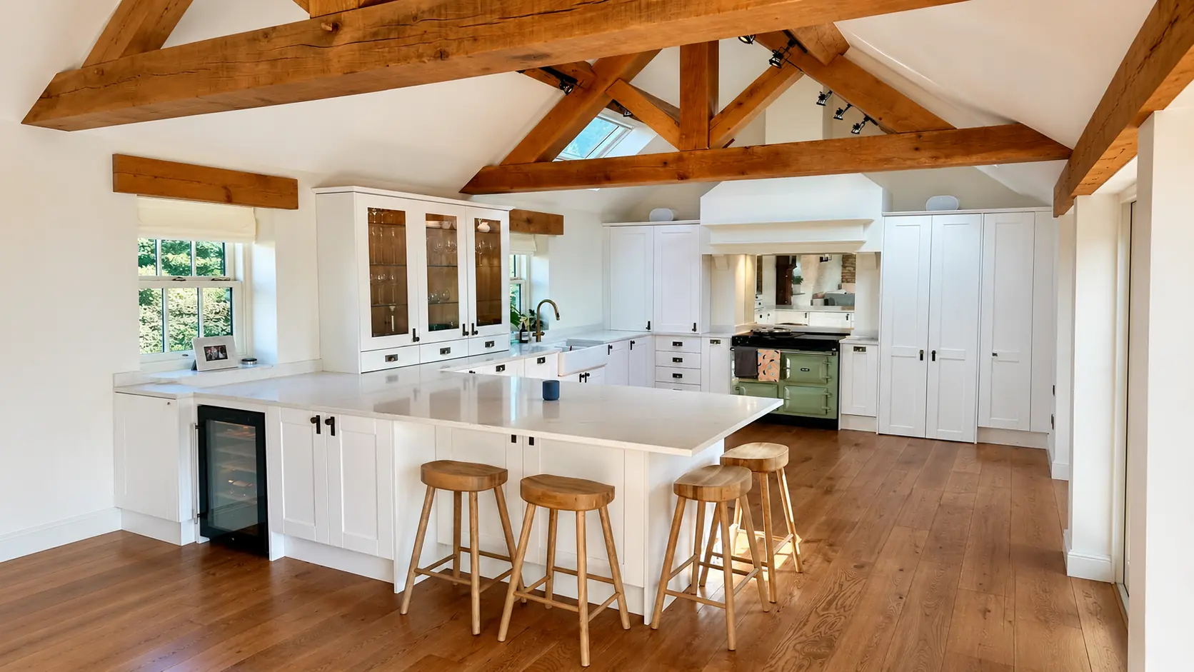 Bespoke painted kitchen with an island and exposed oak roof trusses